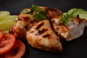 Grilled chicken breast  with cherry tomatoes, herbs, olive oil, pepper,sliced cucumber and herbs.