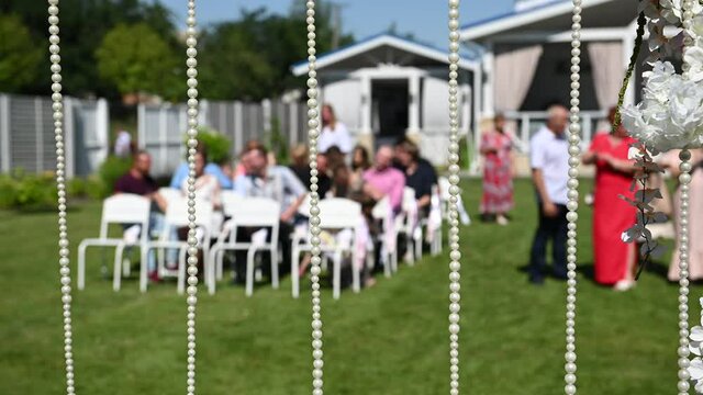 Wedding ceremony decoration on wind. Wind blows colorful ribbons in spring sunlight