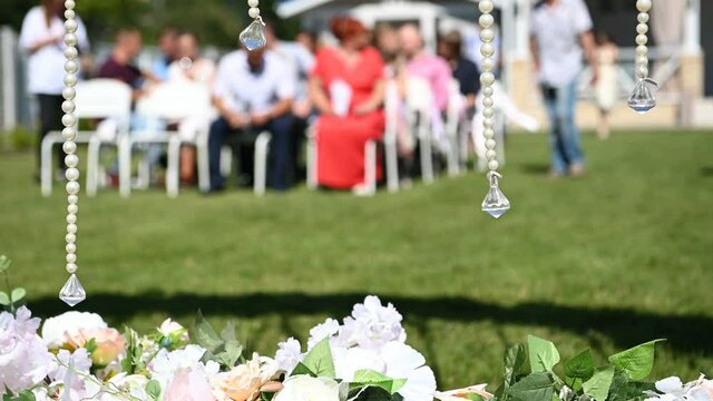 Wedding ceremony decoration on wind. Wind blows colorful ribbons in spring sunlight