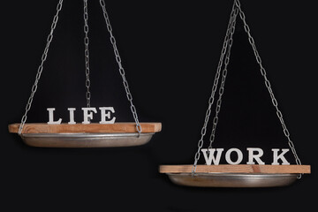 Work and personal life balance concept. Seesaw. Scales on black background close up