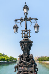 Fototapeta premium Lamparas ornamentado con ángeles en puente sobre el rio en la ciudad de San Sebastian
