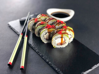 Sushi rolls with avocado dark background