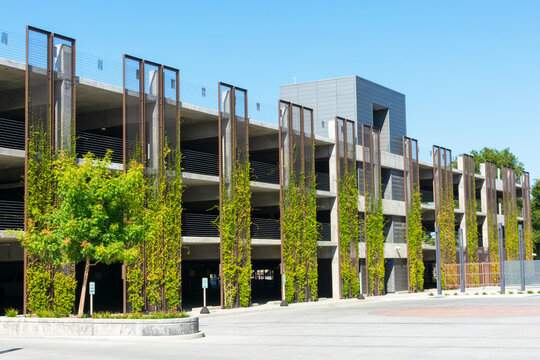Multi level modern parking garage facade and exterior. Green living plant wall.