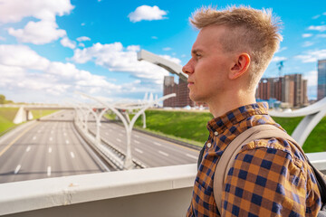 A young blond man in shirt looking at the road section of St. Petersburg Western high-speed...