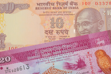 A macro image of a orange ten rupee bill from India paired up with a pink and white twenty rupee bank note from Sri Lanka.  Shot close up in macro.