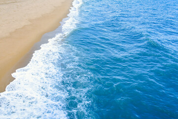 The beach and sea surface with Deep Blue sea clear sky clouds. Landscape with Ocean small waves water reflection copy space for text. Illustration for tourism, website or ad. Andaman sea, Thailand.