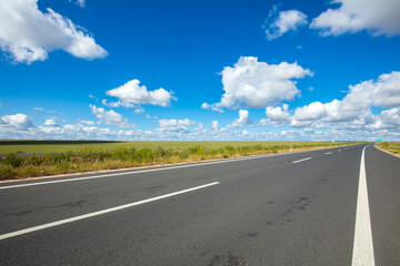 Empty highway, blue sky and white clouds landscape