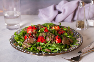Chicken liver salad with strawberries and arugula. Liver and berries salad. horizontal photo