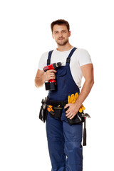 caucasian repairman worker in uniform holding cordless screwdriver. handyman wearing tool belt isolated on white studio background