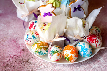Easter bright multicolored eggs with Easter pies on a white ceramic plate