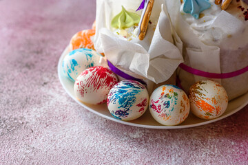 Easter bright multicolored eggs with Easter pies on a white ceramic plate