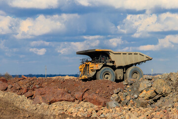Huge yellow mining dump truck working in iron ore quarry. Mining industry © olyasolod