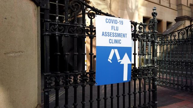 Covid 19 Flu Assessment Clinic sign outside building, slow motion, Sydney