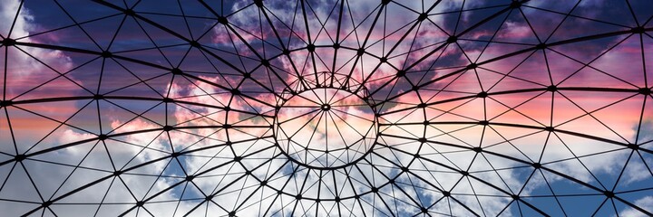 Bottom view of an iron structure with sky and clouds in the sunset. Panoramic image