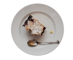 A piece of grated shortcake with jam and a silver spoon on a white plate isolated on white background. Top view. 