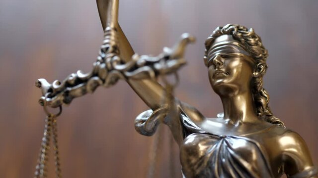 Legal law, patent attorney or successful lawyer concept. Bronze statue of themis or lady of justice on brown background
