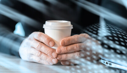 Businessman holding a paper coffee cup; light effect