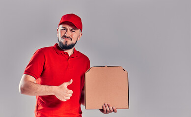 Delivery man in red cap, t-shirt giving food order pizza boxes isolated on gray background. Male employee pizzaman courier holding pizza in empty blank cardboard flatbox copy space. Service concept