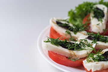 Caprese salad is a low-calorie cold Italian snack. The dish contains 3 ingredients: tomatoes, mozzarella and basil.
