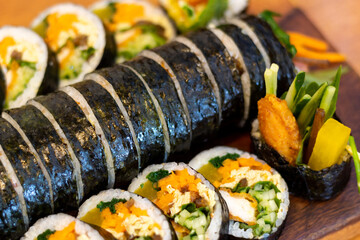Korean kimpab rolls with vegetables and chicken on board close-up