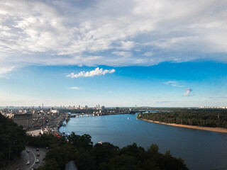Naklejka premium Panoramic view of Dnipro river and side of Kyiv from the point view. Blue sky, green grass and urban landscape of Kyiv, Ukraine.