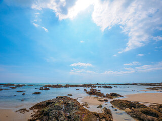 Uninhabited tropical rocky beach with blue sky