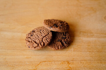 chocolate cookies and dark chocolate grain on wooden board background. for text concept advertising