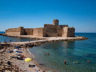 Le Castella, Crotone, Calabria, Italy. Tourists bathe on the beach at Le Castella near Aragonese...