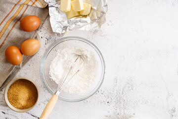 Baking and cooking ingredients on white marble background.