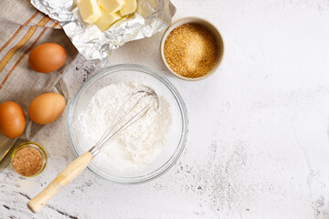 Baking and cooking ingredients on white marble background.