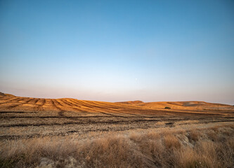 dry fields clay hills called Sciolle at sunset in the province of Crotone, Calabria, Italy.