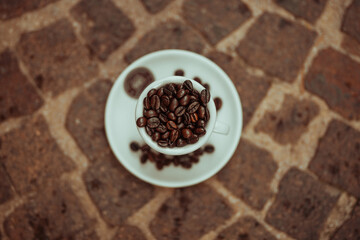 Tazzina da caffè fotografata dall'alto con chicchi di caffè