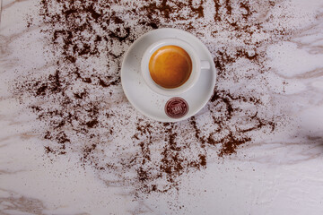 Caffè fotografato dall'alto con la polvere di caffè intorno 