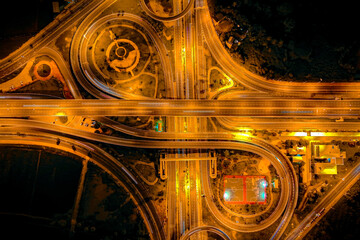 Center focus and long exposure of cross motorway traffic junction road into the city at night