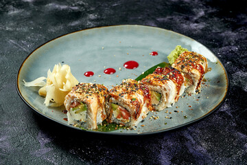 Japanese sushi rolls with eel, salmon, avocado and cream cheese in a blue plate. Close up