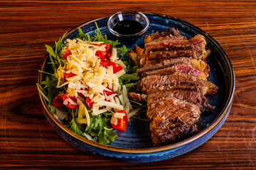 Tagliata di carne con pomodorini, rucola e formaggio e salsa bbq