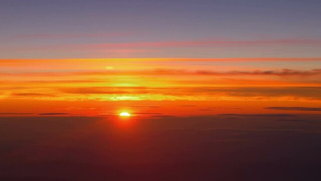 Sunset above the clouds during flight in 4K 