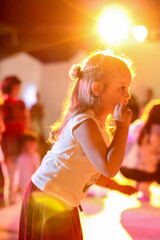 Blurred beautiful emotional young girl dancing in neon light. Human emotions, facial expression concept. Trendy colors.