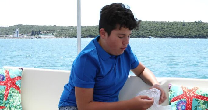 Young boy having a nausea seasickness during the boat trip