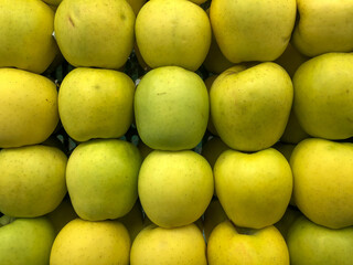 Green apples neatly arranged on display for sale in a shop