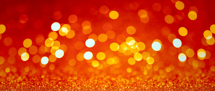 Abstract blurred background, yellow lights on red background. Golden christmas or new year bokeh.