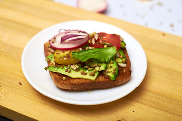 Toasts with vegetables, avocados, tomatoes, a set of seeds. Healthy food, diet concept.