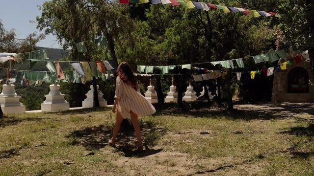 Sensual Woman Walking Around a Tibetan Garden with Prayer Flags