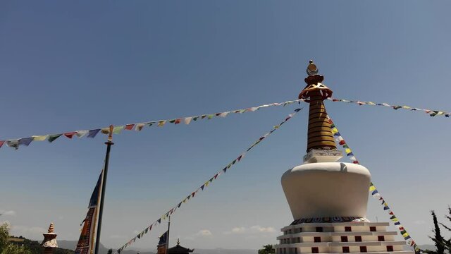 Close Up Ascending Video of the Stupa of a Buddhist Temple with Prayer Flags Fluttering in Wind