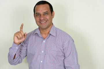 Portrait of happy overweight Indian businessman against white background