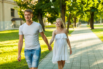 Fototapeta premium pregnant woman with her husband walking in a park