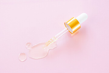 Cosmetic pipette with natural oil on a pink background close-up. Stylish concept of organic essences, beauty and health products. Copy space, minimalism, flat lay. Modern apothecary.