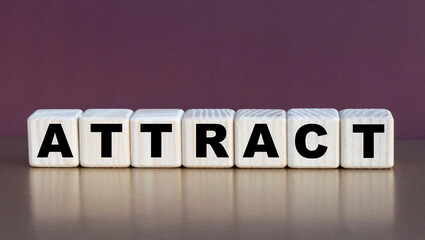 Obraz premium ATTRACT - the word on the cubes on a beautiful burgundy background
