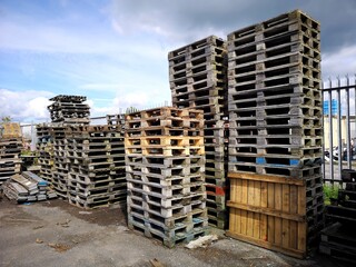 Shipping pallets stored in an outside yard. They are stacked and ready for use in the transportation of manufactured goods.