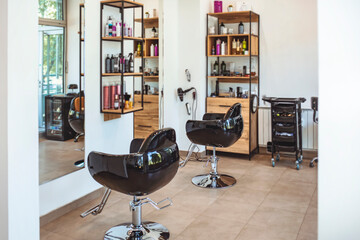 Workshop of hairdressers. Beauty salon with chairs, hair dryers, combs and mirrors. Interior of...